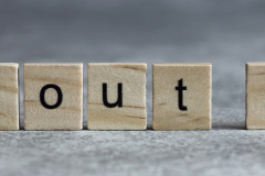 About us word written on wood cube with gray background.
