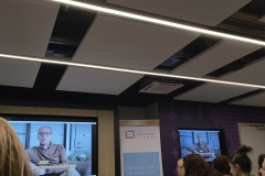 Theo Paphitis welcomes SBS attendees to the event via a video message display on TV screens on the right and left with a Small Business Sunday banner in the centre.